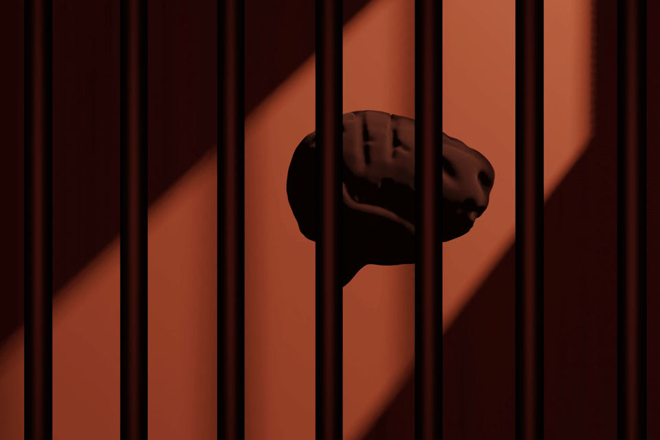 A brain turns slowly behind bars in a prison cell.