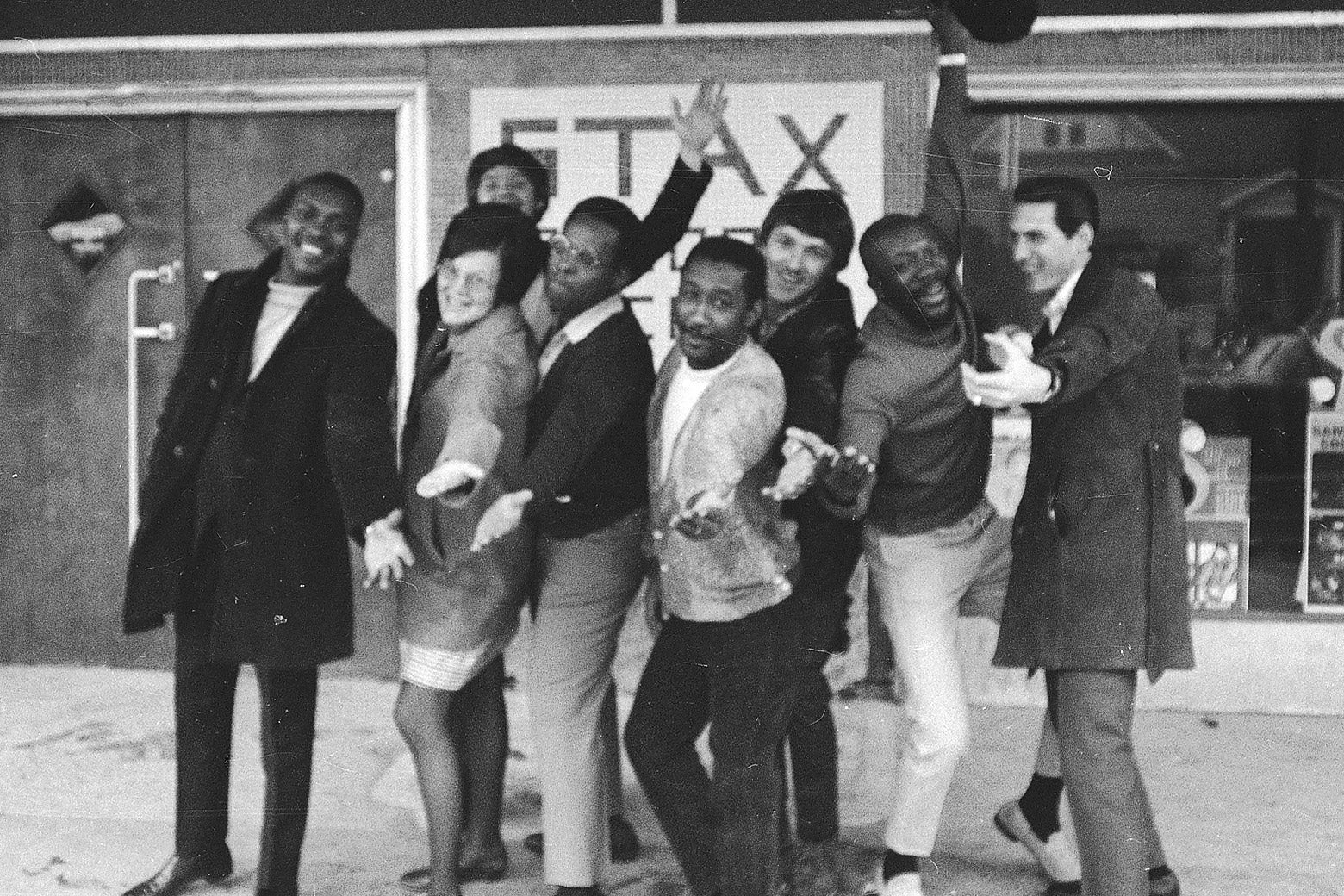 Black-and-white photo of a group of musicians standing in front of Stax records.