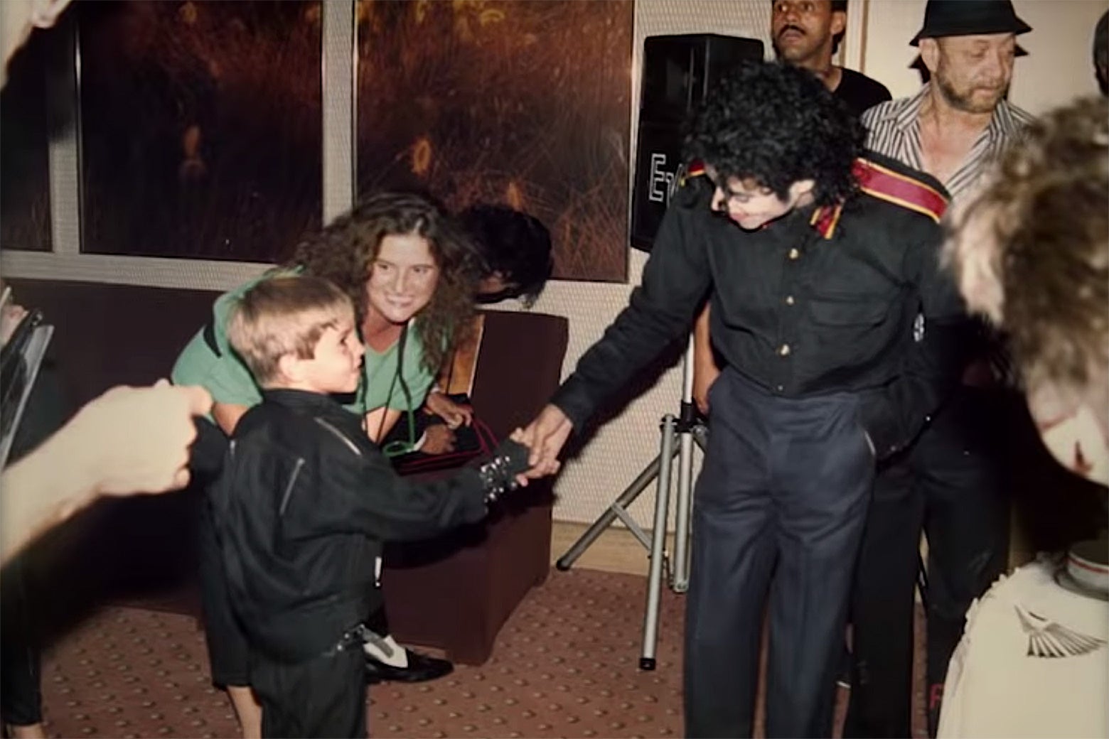 Michael Jackson shaking hands with a young James Safechuck dressed in an outfit inspired by the album Bad.