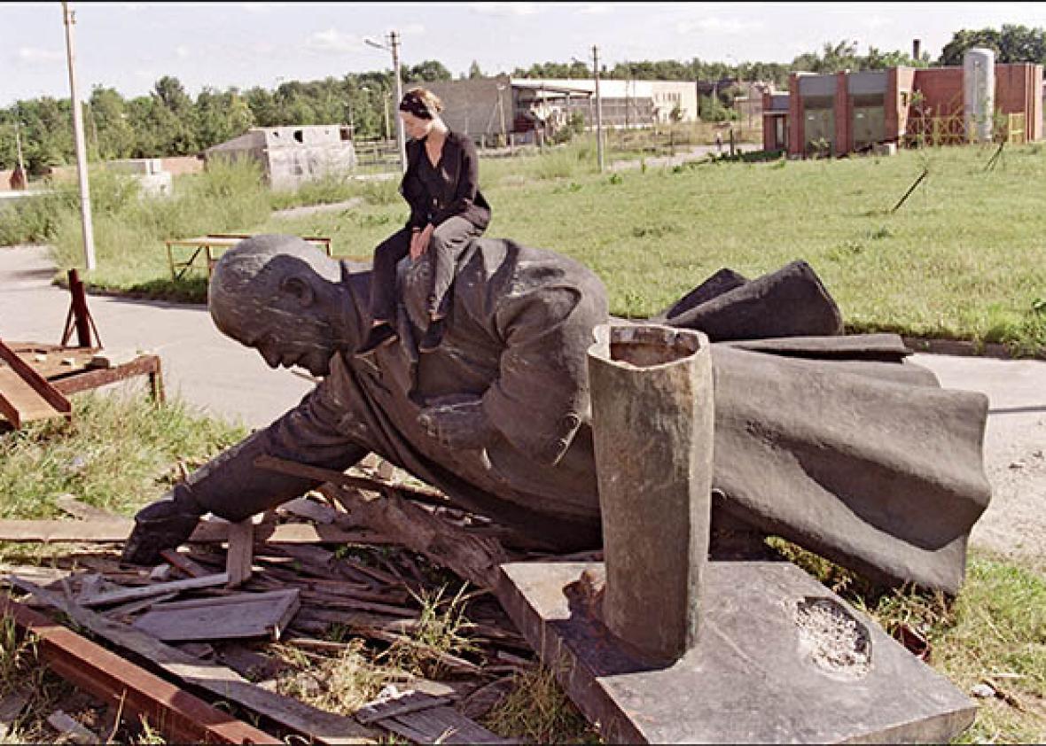 Lithuanian girl sits on the toppled statue of Vladimir Lenin.