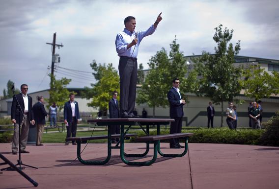 Mitt Romney hops on a picnic table in colorado.