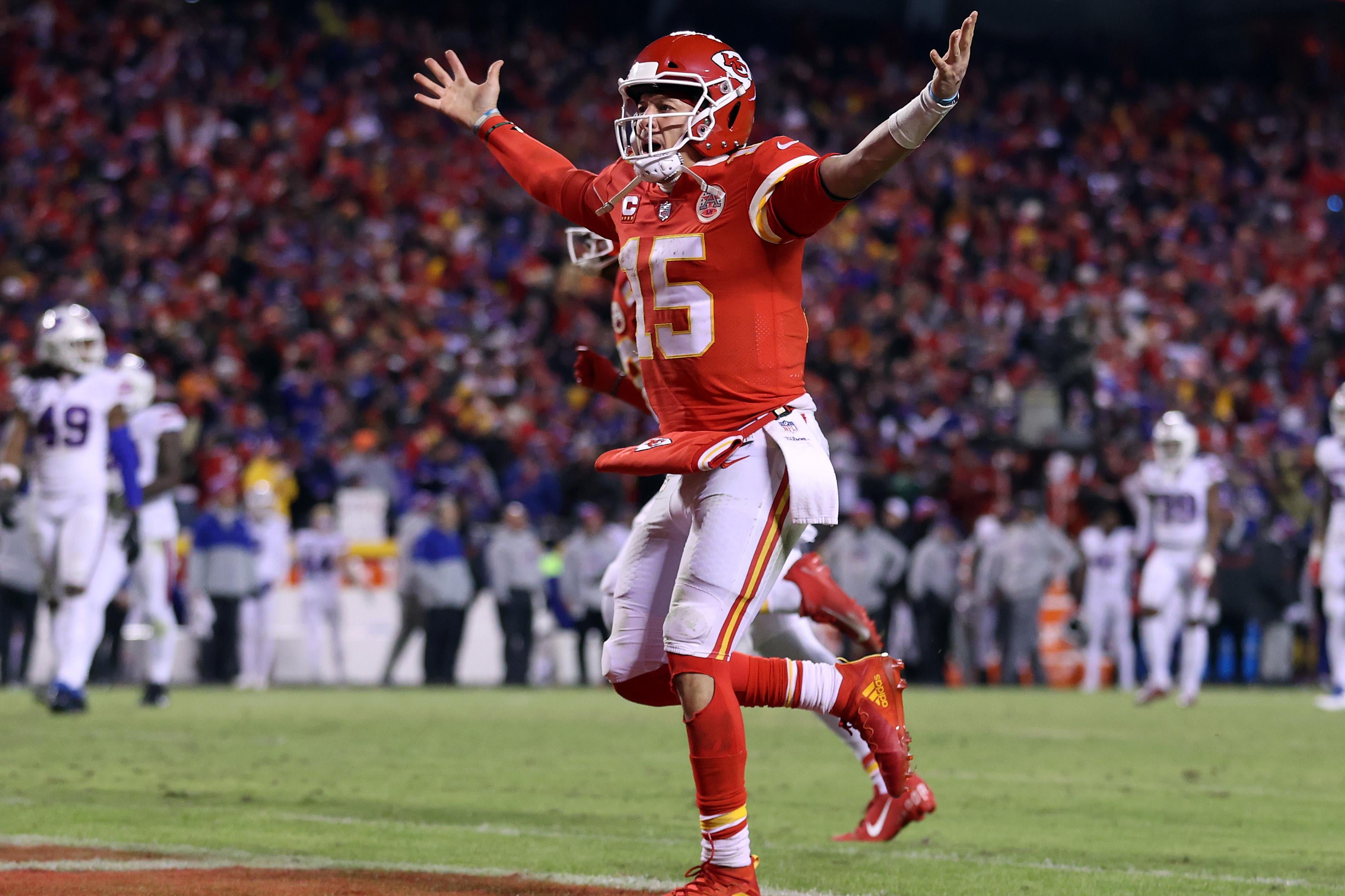 Patrick Mahomes celebrates on the field with his arms outstretched.