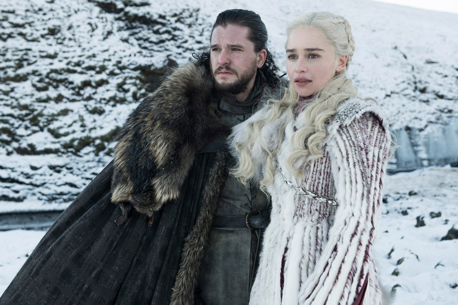 In a still from Game of Thrones, Jon Snow and Daenerys Targaryen stand beside each other in a snowy landscape.