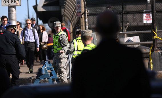 People walk to work by National Guardsman near the scene of twin bombings at the Boston Marathon on April 17, 2013 in Boston, Massachusetts. 