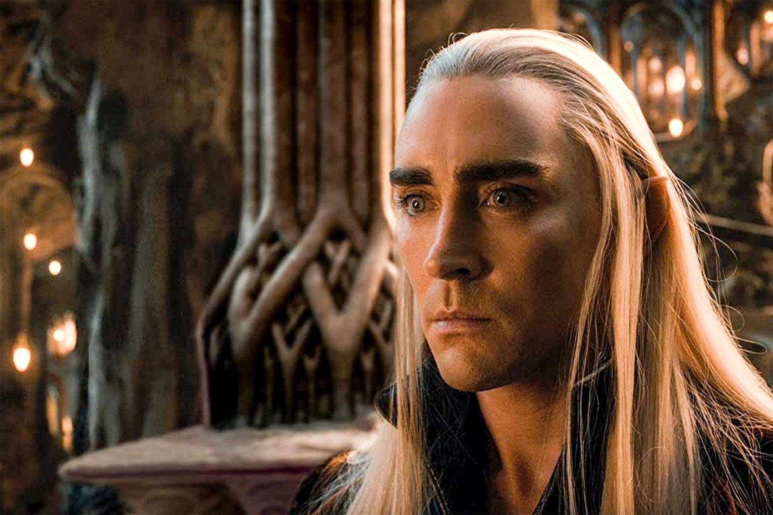 Elf with long golden hair, pointy ears, and blue eyes staring