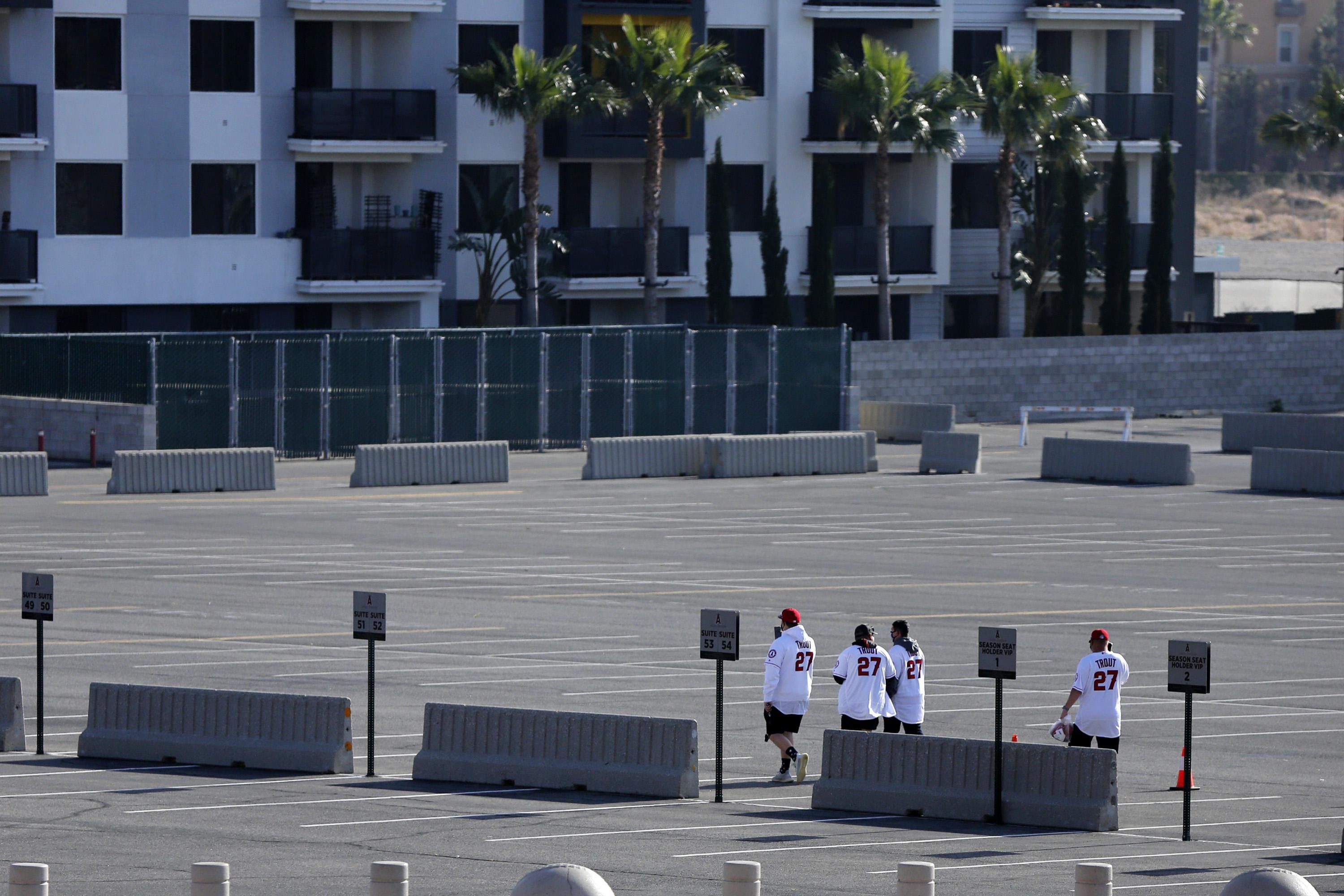 ANAHEIM, CALIFORNIA - APRIL 17: A group of fans wearing Mike Trout #27 jerseys walk through the parking lot after it was announced that the game between the Los Angeles Angels and the Minnesota Twins was postponed at Angel Stadium of Anaheim on April 17, 2021 in Anaheim, California. (Photo by Katharine Lotze/Getty Images)