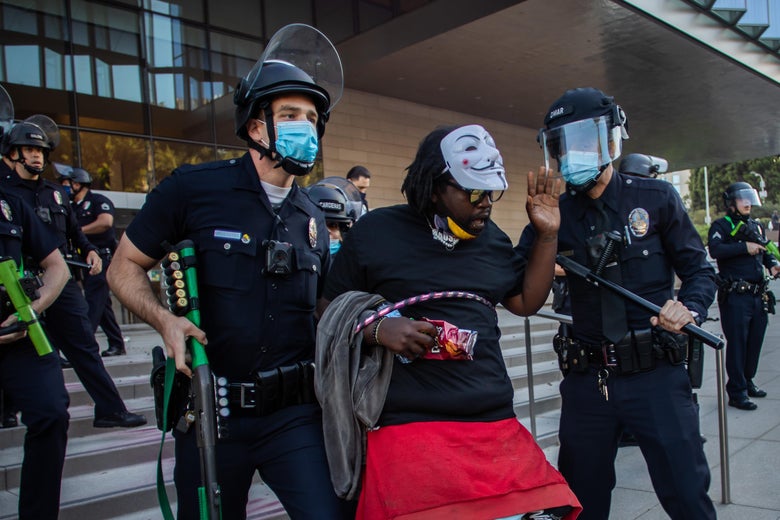 Cops with helmets and batons drag a man from courthouse steps, where other cops are arranged.