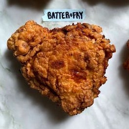 A cooked, battered chicken thigh labeled Batter + Fry.