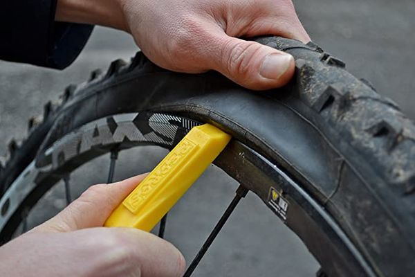 Hand using Pedro’s Tire Levers on a bike.