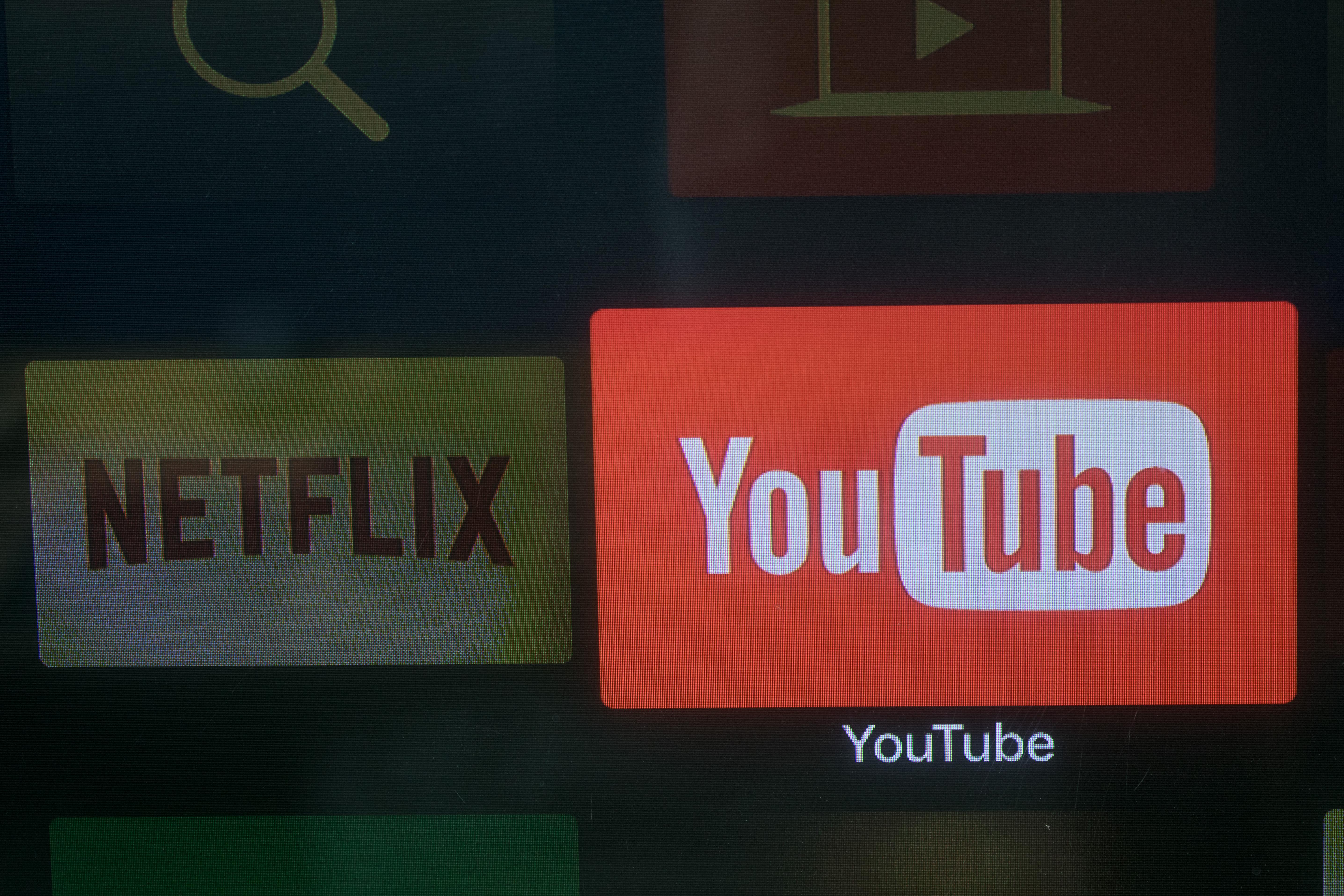 The YouTube and Netflix app logos are seen on a television screen.