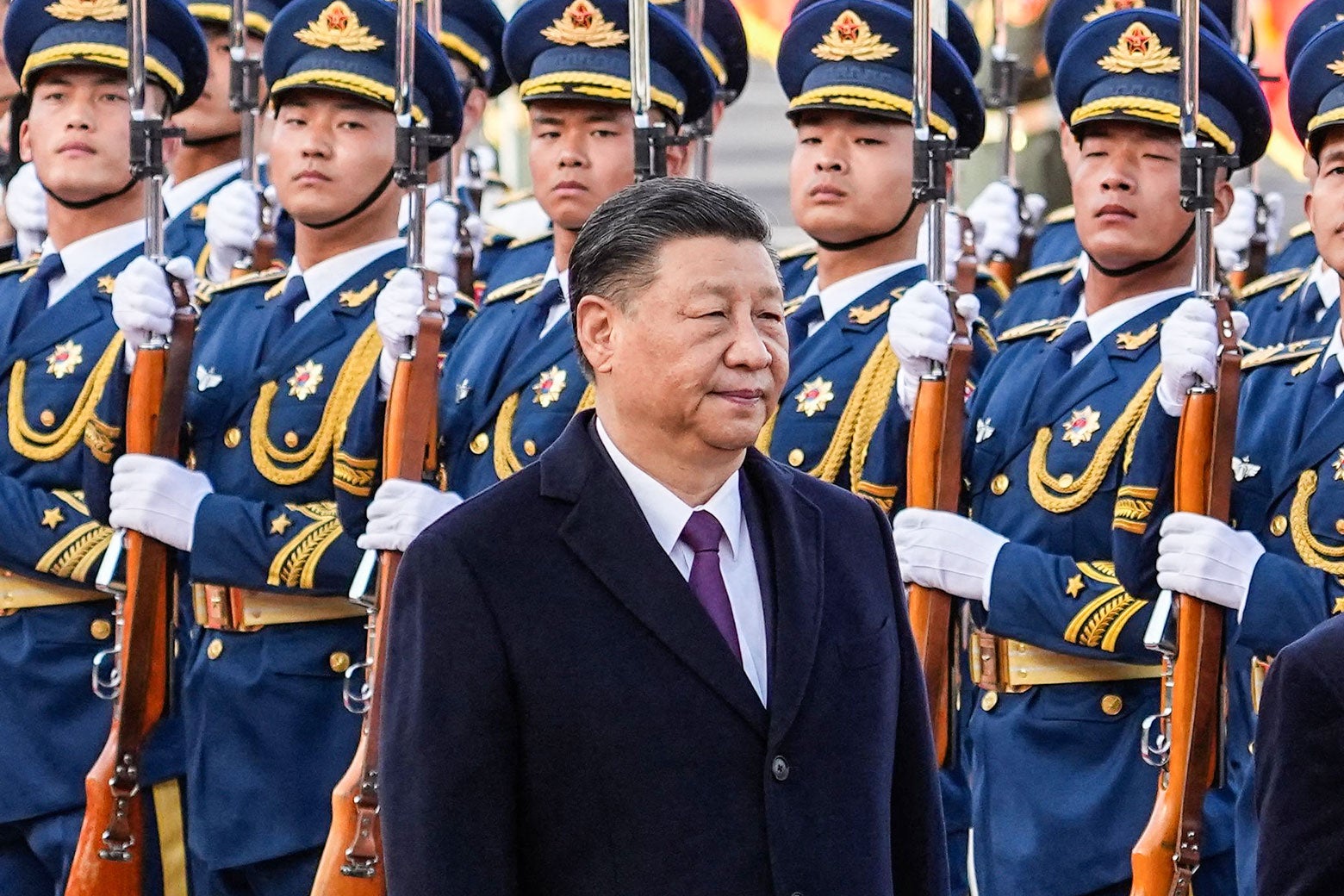 Chinese President Xi Jinping stands in front of a row of soldiers.