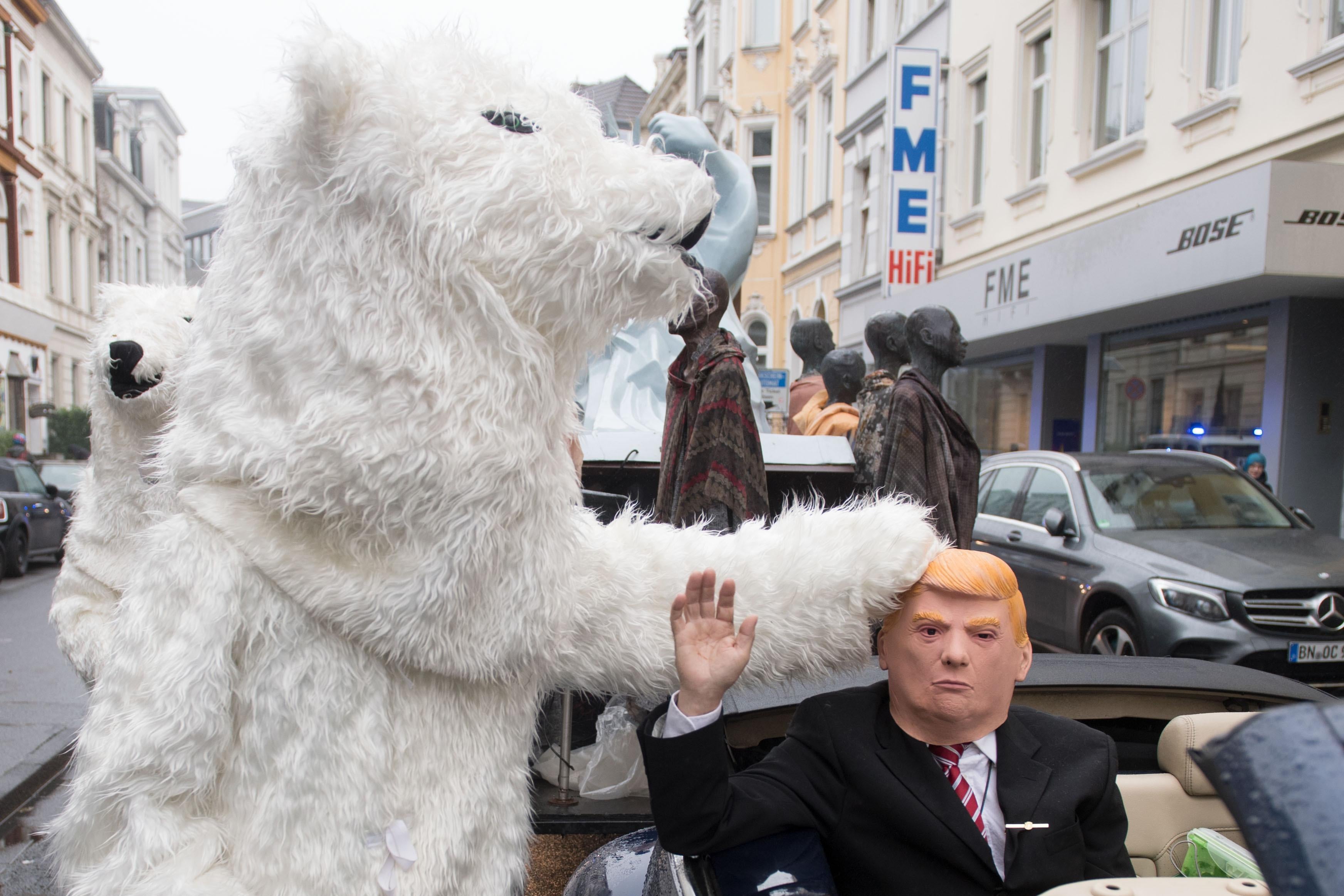 A demonstrator dressed as Donald Trump parades with other activists dressed as polar bears