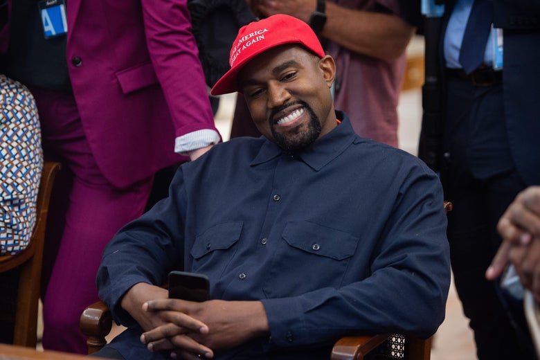 Kanye West in the Oval Office with his phone in his hands.