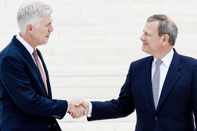 Neil Gorsuch shakes hands with John Roberts.