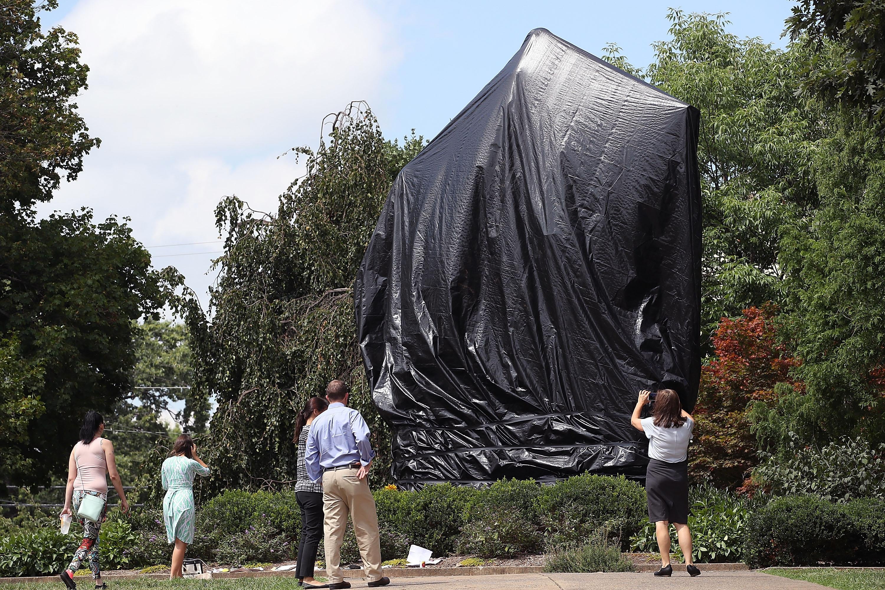 The statue of Confederate Gen. Robert E. Lee covered with a black tarp.