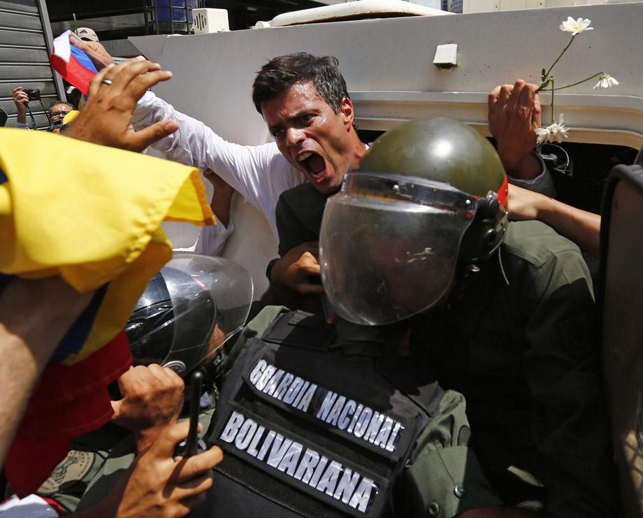 Venezuelan opposition leader Leopoldo Lopez gets into a National Guard armored vehicle in Caracas February 18, 2014. Lopez, wanted on charges of fomenting deadly violence, handed himself over to security forces on Tuesday.