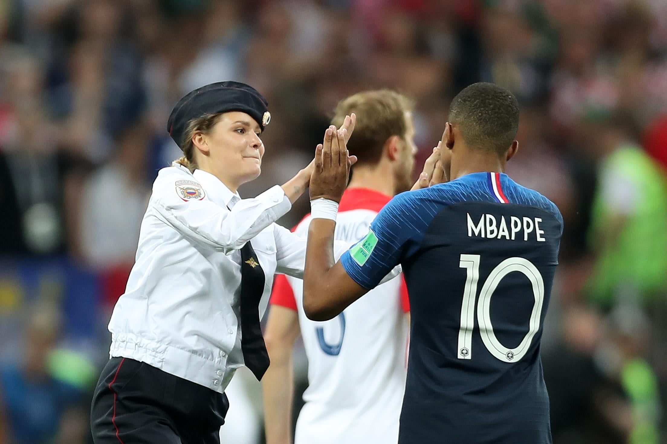 MOSCOW, RUSSIA - JULY 15:  A pitch invader high fives Kylian Mbappe of France during the 2018 FIFA World Cup Final between France and Croatia at Luzhniki Stadium on July 15, 2018 in Moscow, Russia.  (Photo by Clive Rose/Getty Images)