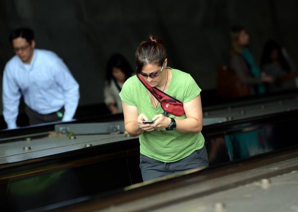 Woman checks her BlackBerry while riding an escalator in Washington, D.C.