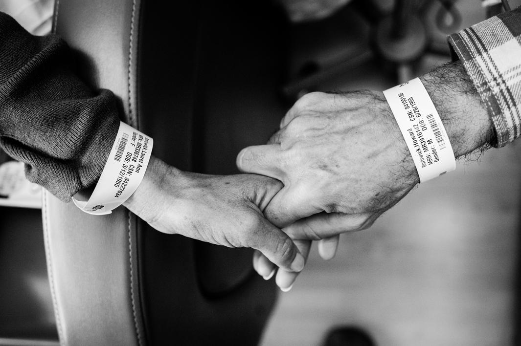 Like wedding rings, Laurel and Howie Borowick wear similar medical bracelets, which the nurses scan throughout their chemotherapy treatments together at the oncologists office. They do a dance, as both caretaker and patient and husband and wife, simultaneously trying to be there for the other but also trying to get through the day them selves. Greenwich, Connecticut. January, 2013.