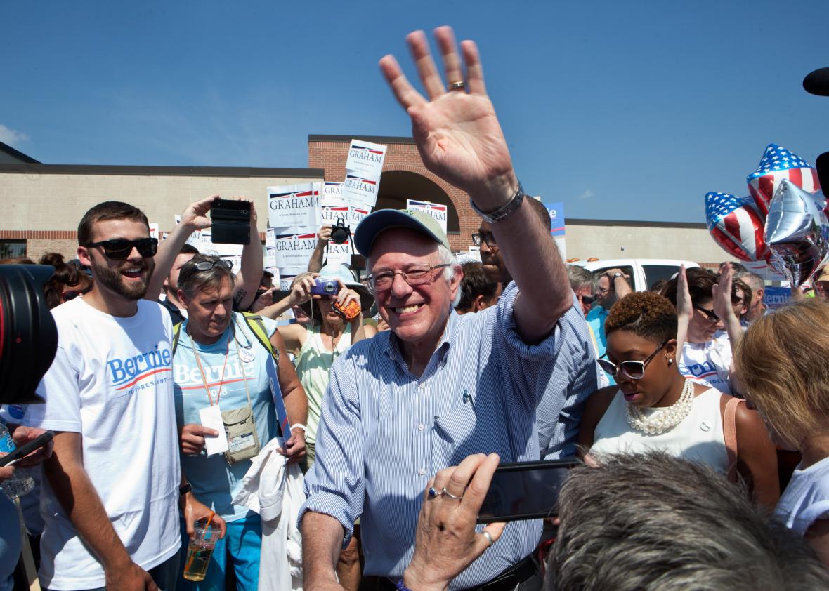 Bernie Sanders shakes hands with supporters at a rally