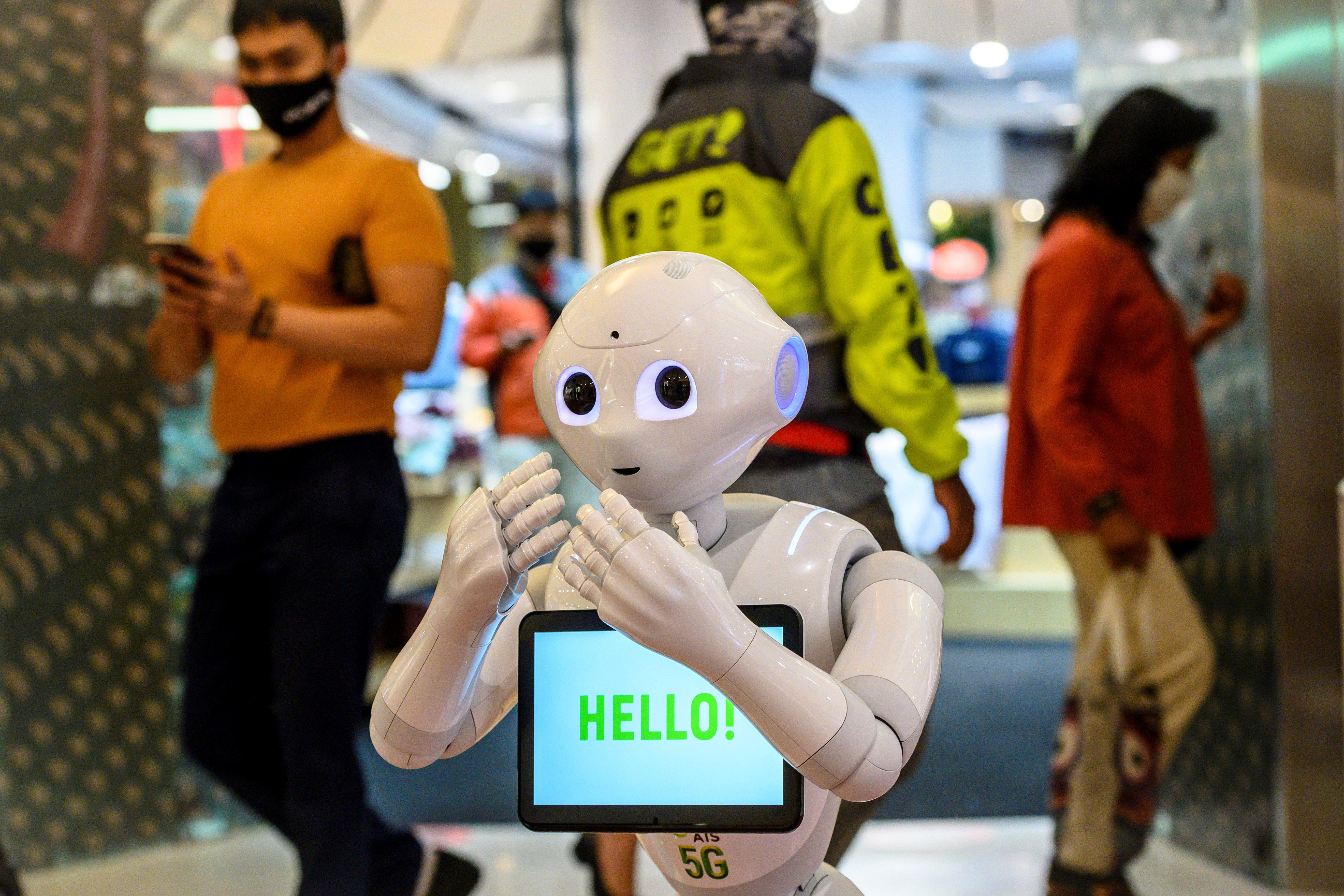 A white robot with a tablet that says "Hello"