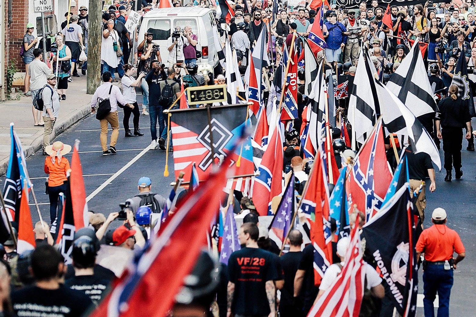 A group of white supremacists and other alt-right figures wave flags and march in Charlotesville.