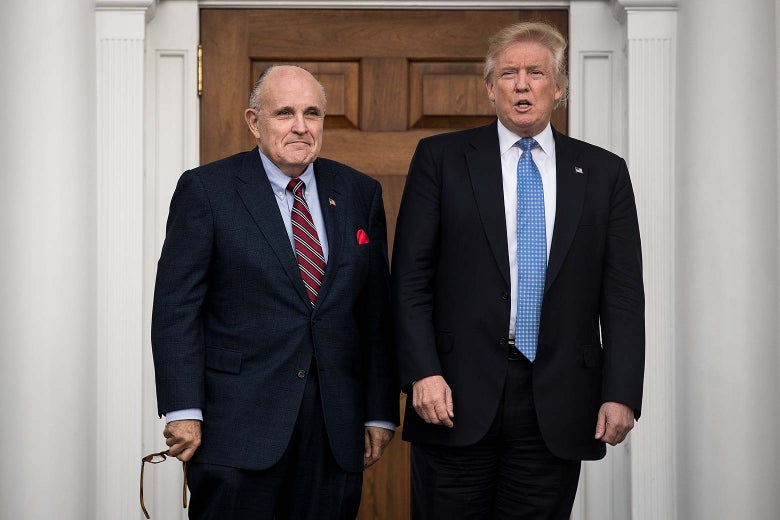 Rudy Giuliani and Donald Trump stand outside in front of a door.