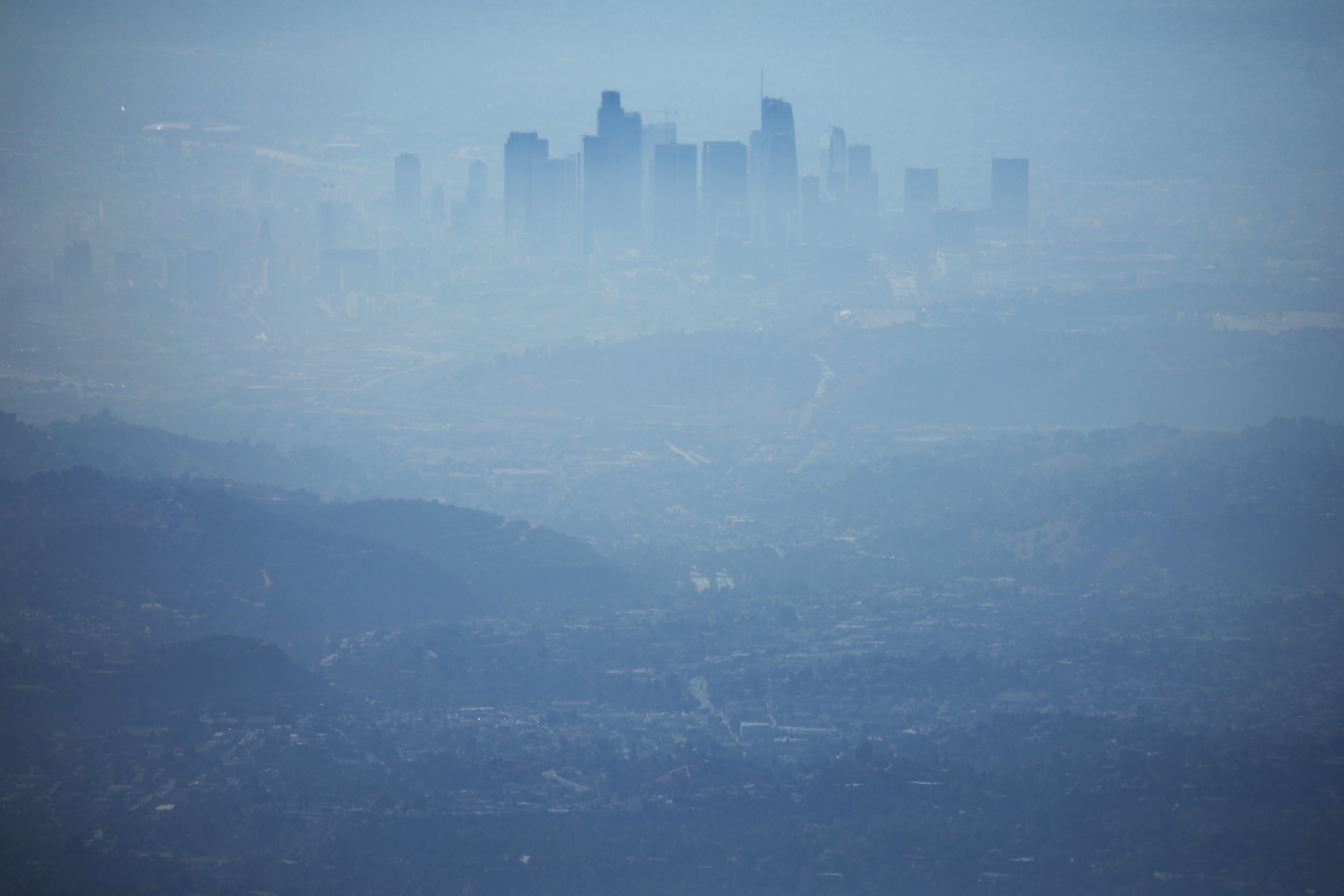 The skyline of down town Los Angeles, as seen from a nearby hilltop, is covered in hazy midday smog.