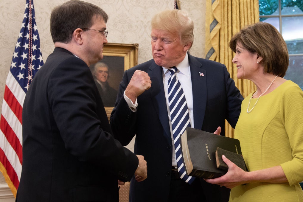 Trump, who is between Wilkie and his wife, pumps his fist.