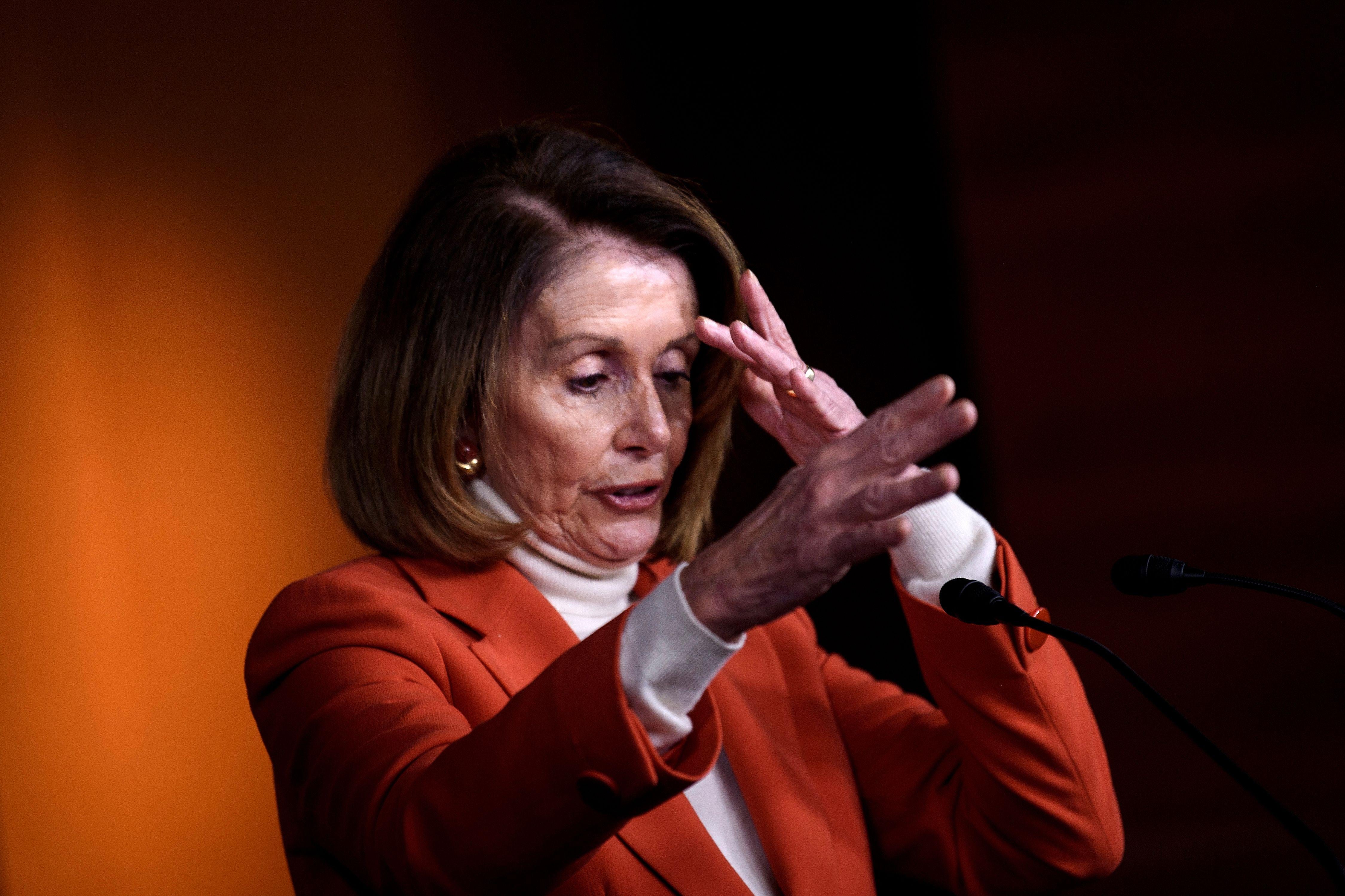 Nancy Pelosi gestures as she speaks to reporters
