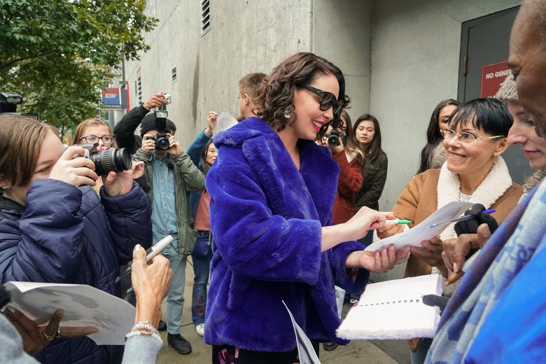 Katherine Heigl as her character in Firefly Lane in a blue coat signing autographs.