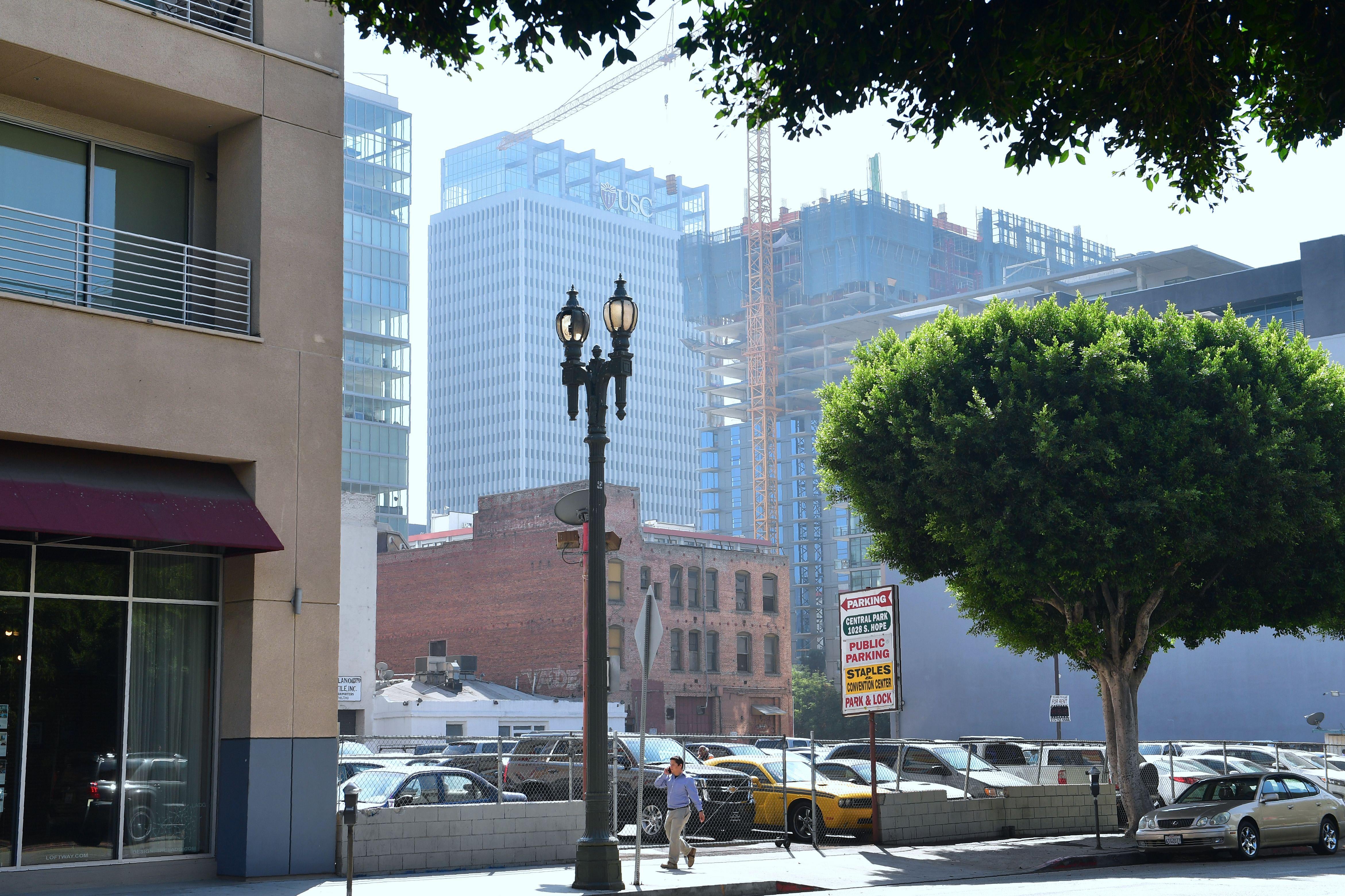 A pedestrian is dwarfed by new high-rise developments in downtown Los Angeles.