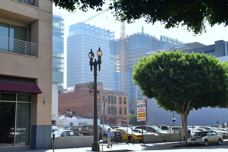 A pedestrian is dwarfed by new high-rise developments in downtown Los Angeles.