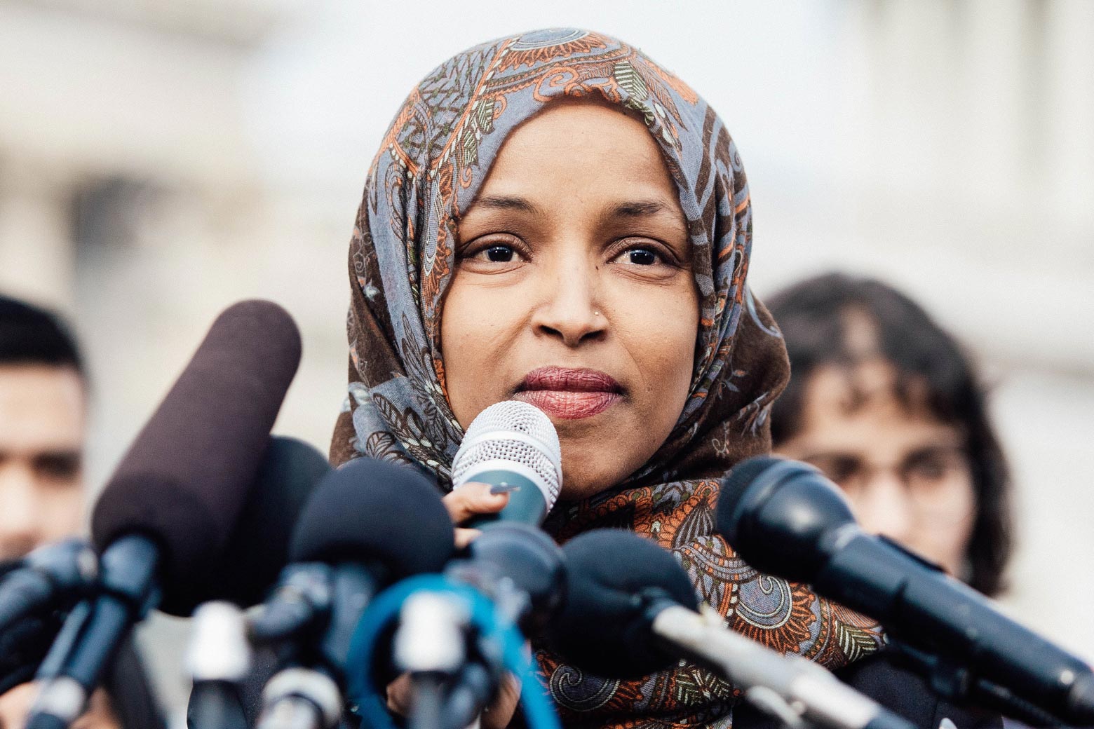 Ilhan Omar with microphones in front of her.