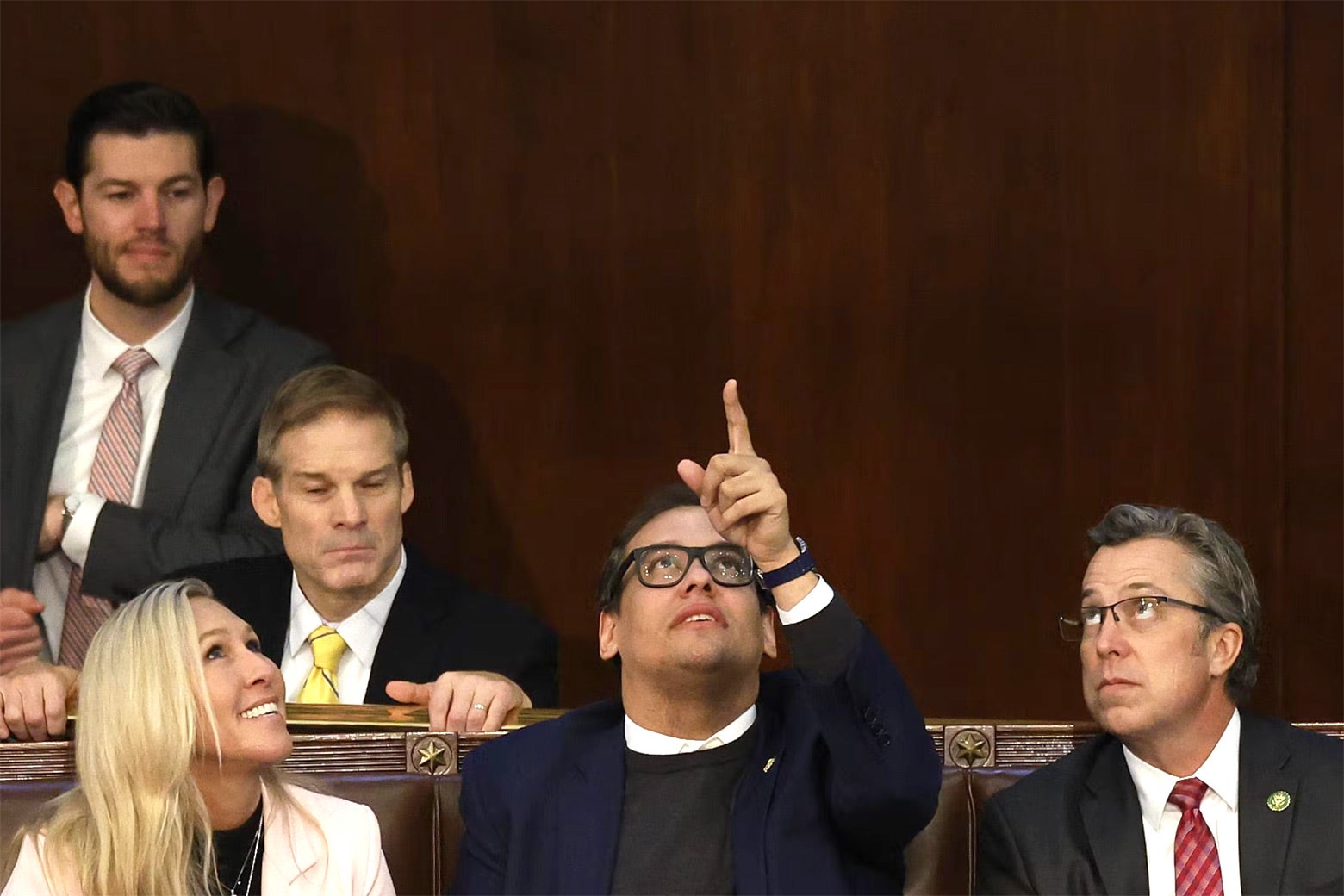 George Santos, sitting and pointing to the ceiling, is surrounded by Marjorie Taylor Greene, Any Ogles, and Jim Jordan.