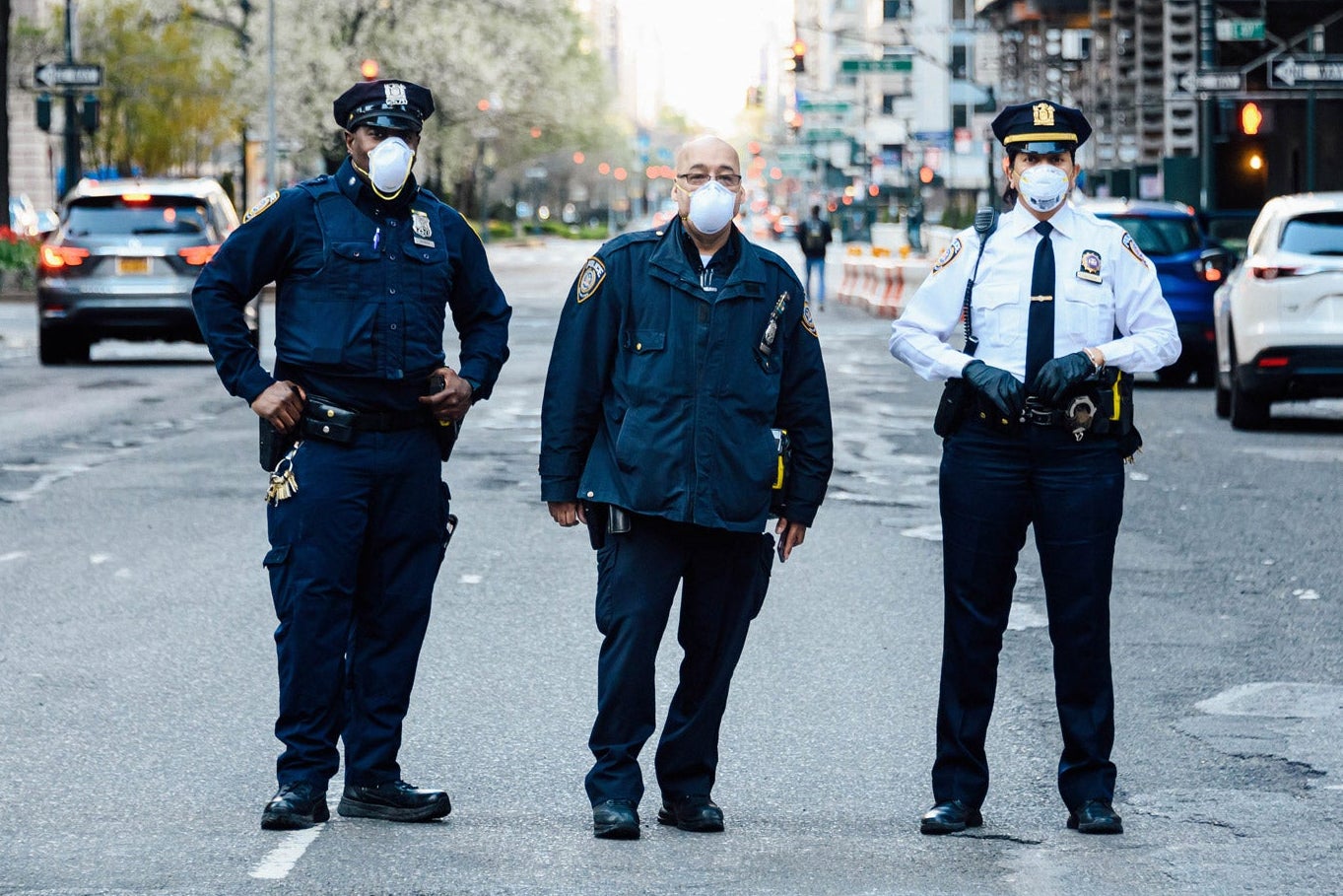 Three police officers blocking a road in NYC. 