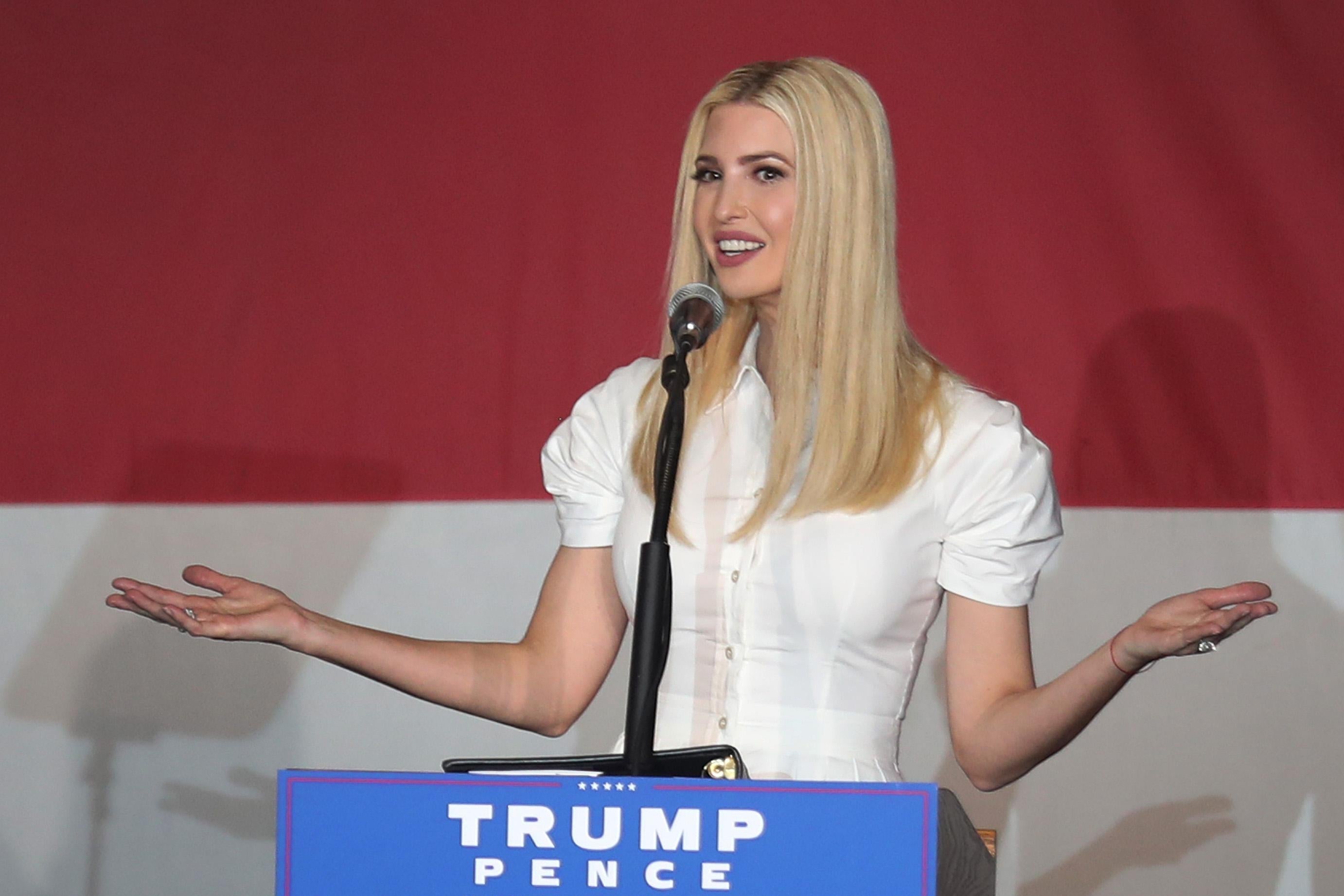Ivanka Trump, wearing white, gestures with her arms as she speaks at a podium onstage