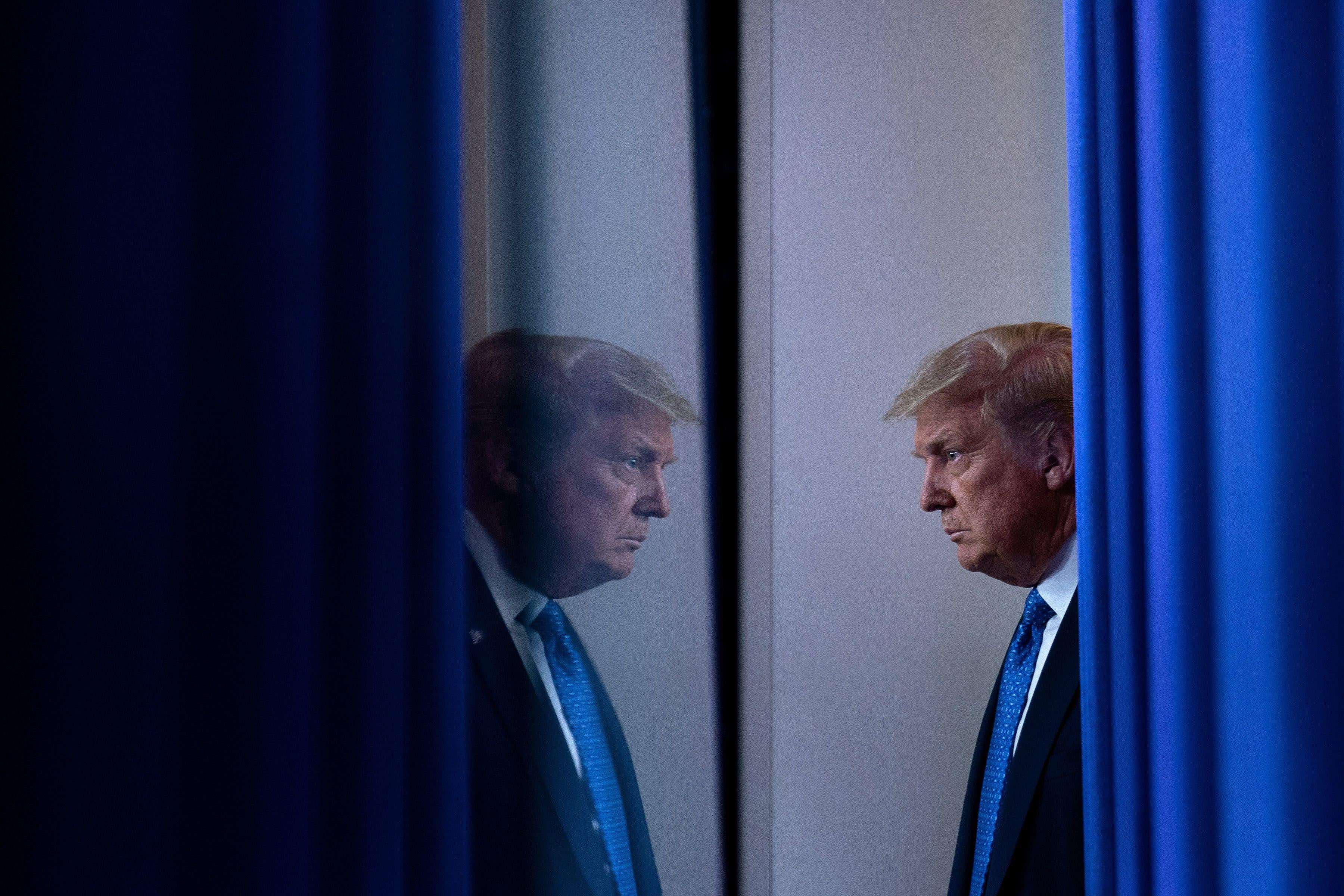 President Donald Trump appears to look at himself in a mirror.