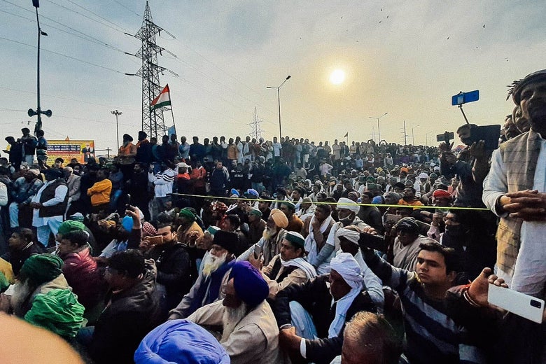 A crowd of people with a hazy sun in the background.