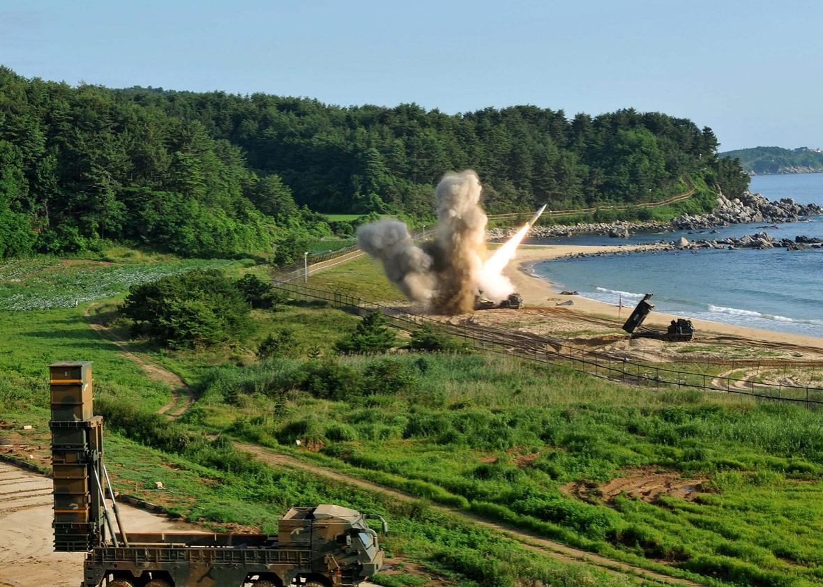 In this handout photo released by the United States Forces Korea, U.S. M270 Multiple Launch Rocket System (R) firing an MGM-140 Army Tactical Missile 