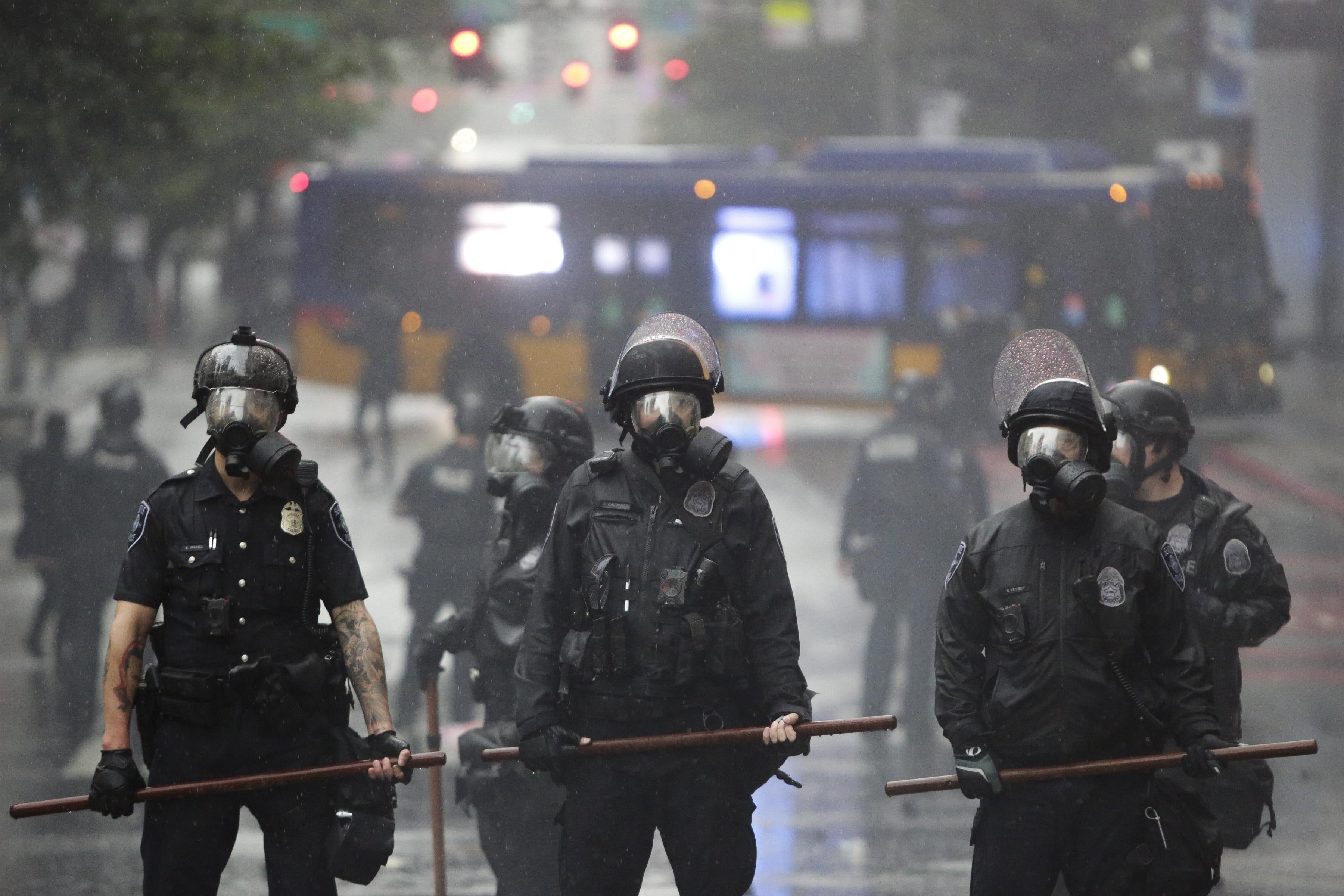 Police in gas masks stand in the street after protests in Seattle, Washington on May 30, 2020.