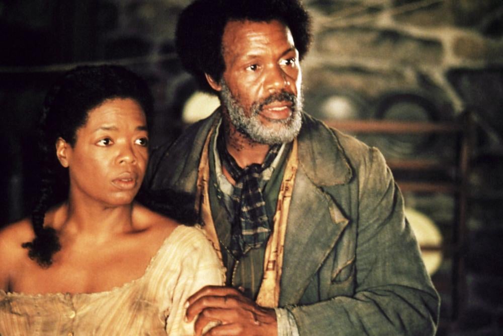 Danny Glover puts his hand on Oprah's arm as the two stare at something off camera.