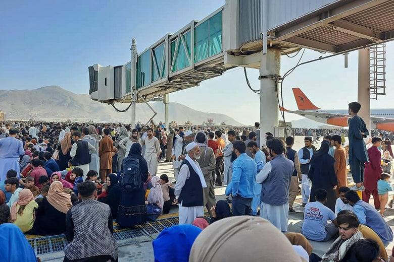 A crowd of Afghans waits on the tarmac of the Kabul airport.
