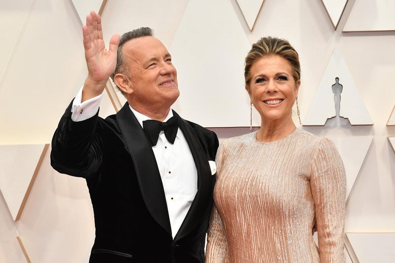 Tom Hanks, in a tuxedo, and Rita Wilson, in a beige evening gown, on the red carpet at the academy awards.