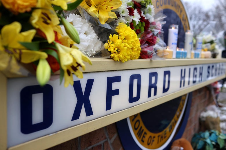 An Oxford High School sign covered in flowers and candles