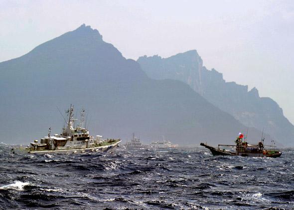 A Taiwan fishing boat (R) is blocked by a Japan Coast Guard (L) vessel near the disputed Diaoyu/Senkaku islands in the East China Sea.