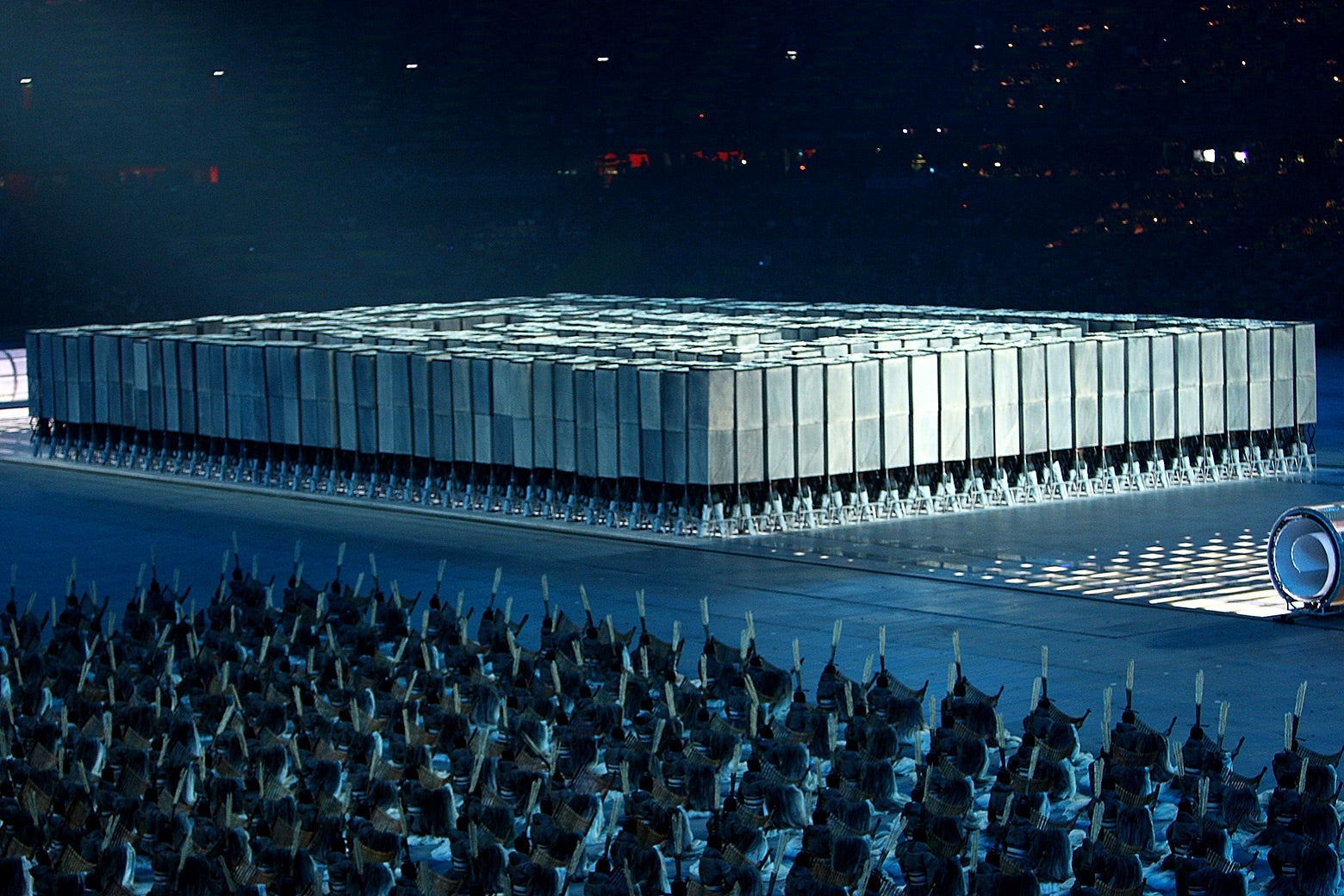 Hundreds of performers holding up boxes in perfect formation on the floor of the Olympic Stadium