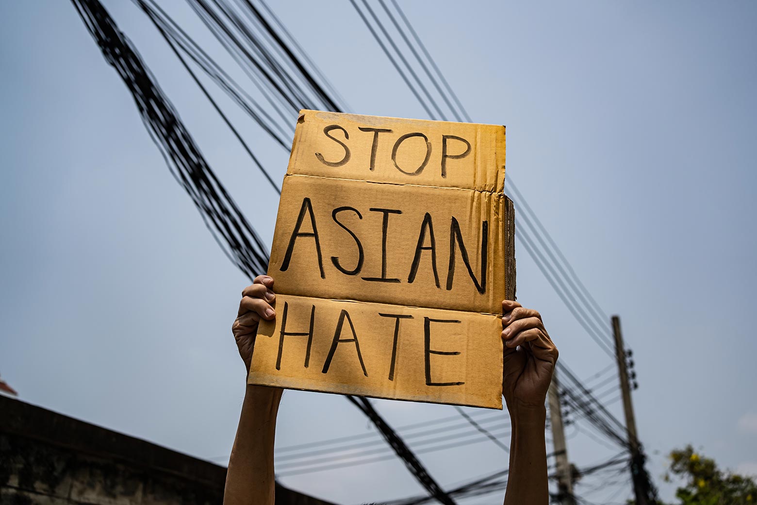 Hands hold a sign reading "Stop Asian Hate."