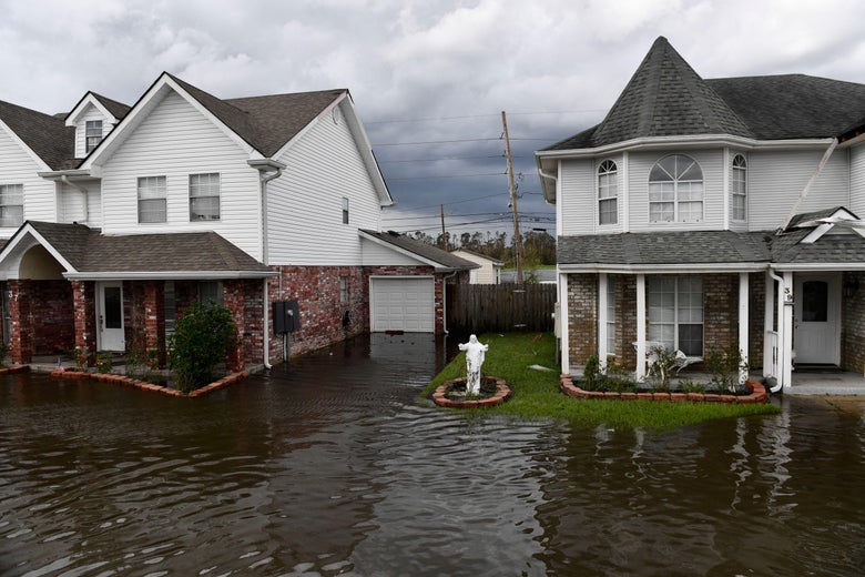 A statue of Jesus Christ stands outside of homes after a neighborhood flooded.
