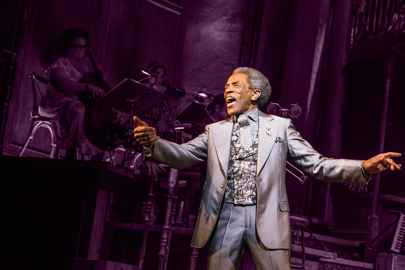 André De Shields singing onstage with his arms outstretched